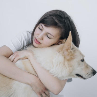 A woman hugging a dog.